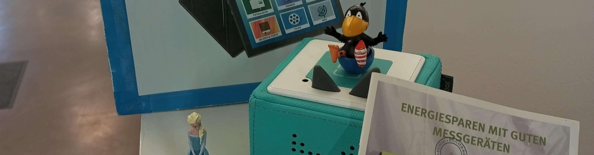 Demenztablet, Toniebox und Energiesparparket stehen auf einem Tisch zur Präsentation Header_Geraete.jpg