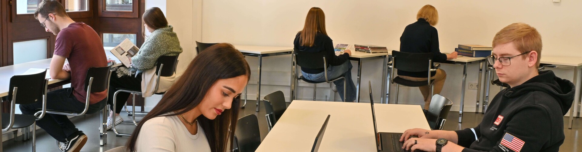 Verschiedene Menschen beim Lernen, mit Buch und/oder Laptop Header_Lernen_in_der_Buecherei.jpg