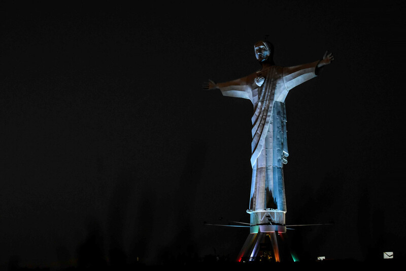 Bunt beleuchtete Statue "Christo Rey del Valle" bei Nacht