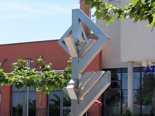 Stadtzeichen "Raumzeichen am Wege" im Gebiet Kreuzäcker mit einem Café im Hintergrund