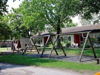 Streifelbach Spielplatz mit Schaukeln und ein Gebäude im Hintergrund
