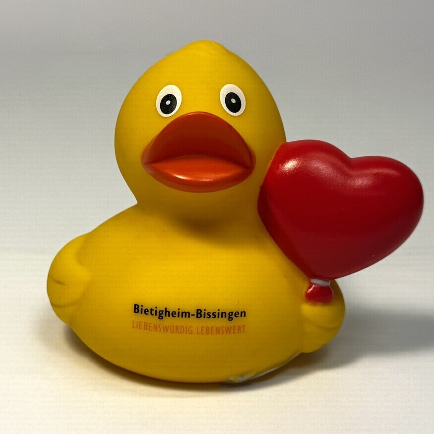 Gelbe Quitsche-Ente die ein rotes Herz hebt