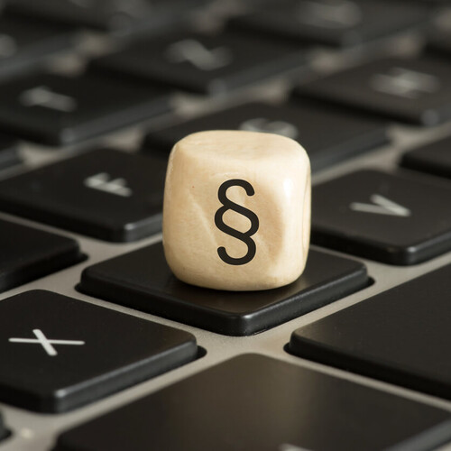 Würfel mit einem Parapgraphen-Symbol liegt auf einer Tastatur Header_Benutzungsordnung.jpg