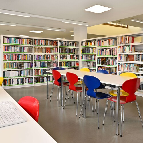 Lernbereich der Jugendbücherei: Zu sehen sind Tische mit Stühlen, Computerarbeitsplätze und Bücherregale Header_weiterfuehrende_Schule.jpg