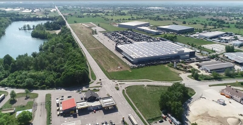 Schrägluftbild: links Natur und Gewässer; rechts ein Industriegebiet