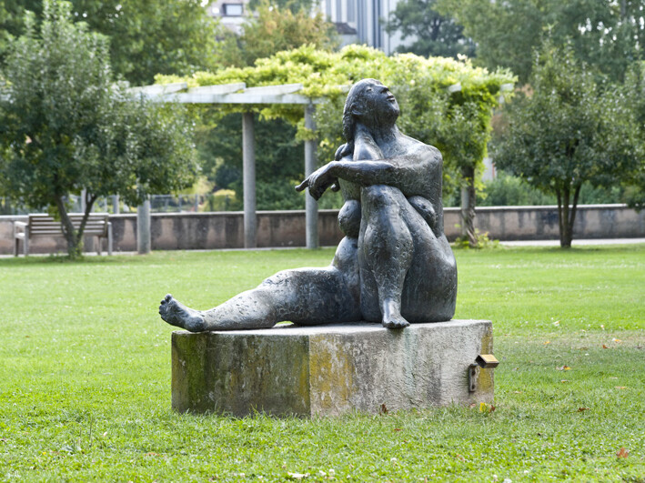 Skulptur die Hockende auf einer Wiese