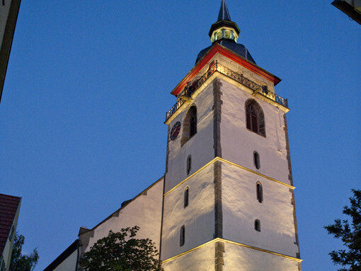 Beleuchteter Kirchturm in einer Altstadt