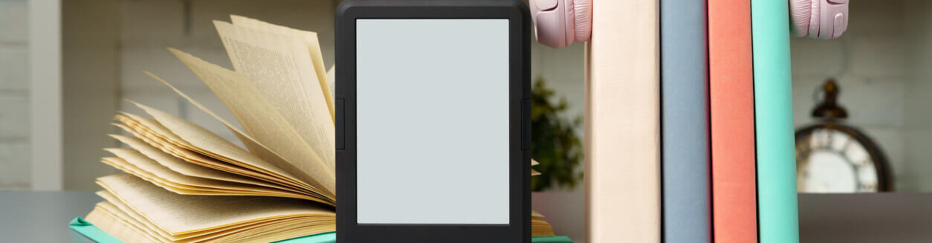 Ein Buch, ein E-Reader und 3 Bücher gehalten von einem Kopfhörer Header_Unsere_Angebote.jpg