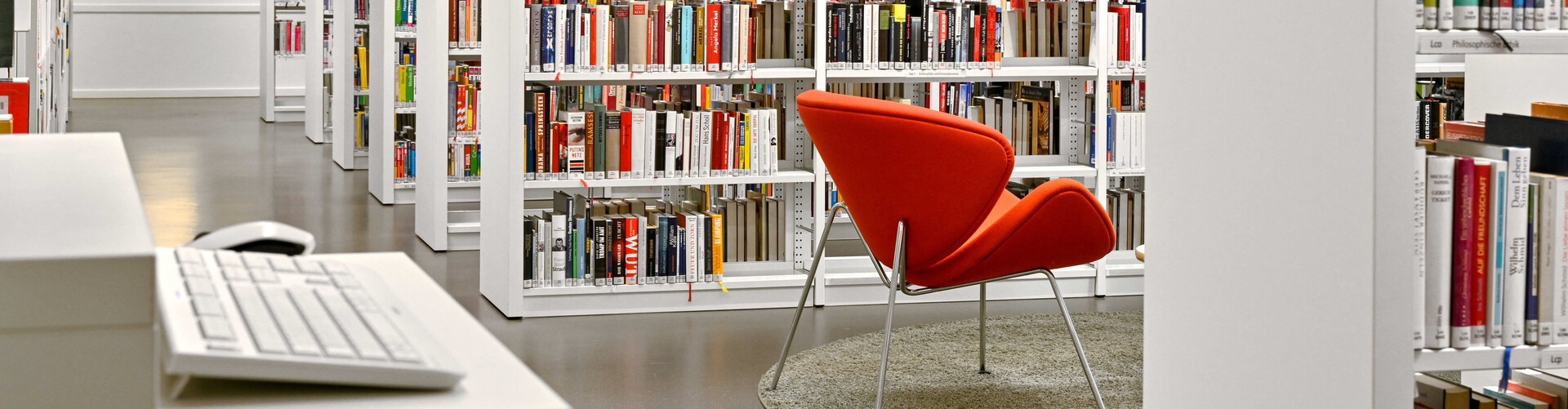 Recherche-PC im Vordergrund, ein Sessel und Bücherregale im Hintergrund Header_Standorte.jpg