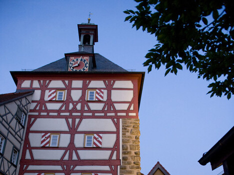 beleuchteter Fachwerkturm mit großen und kleinen Torbögen 